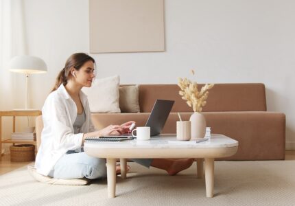 Kvinde sidder på gulv og arbejder på computer