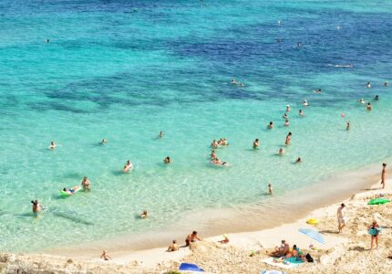 Folk bader på en strand i Mallorca