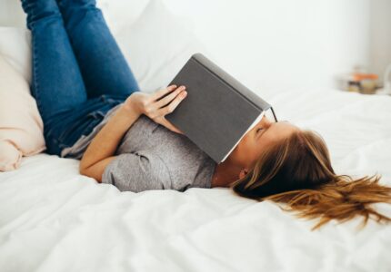 Kvinde læser bog i sin seng